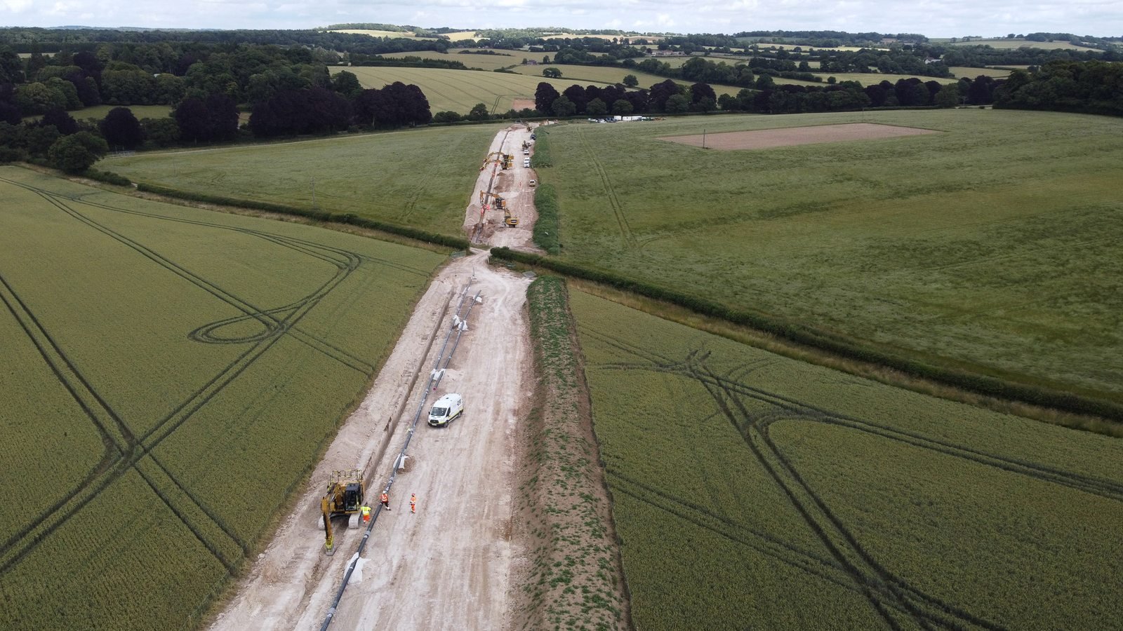 Aerial view of a finished utility line right-of-way restored through green fields